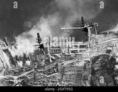 Handley Page Halifax der 35. Staffel der RAF bombardiert die deutschen Schlachtkreuzer Scharnhorst und Gneisenau in Brest, 18. Dezember 1941. Die Schiffe befinden sich auf der linken Seite, von denen sich schnell ein Rauchschirm ausbreitet. Stockfoto