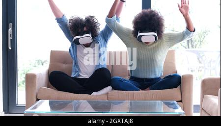 Multiethnische paar mit virtual-Reality-Kopfhörer im Wohnzimmer zu Hause Menschen spielen mit neuen Trends-Technologie Stockfoto