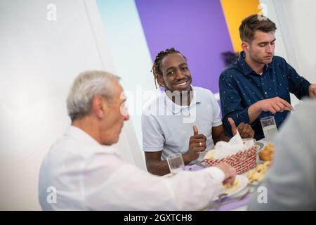 African American man Iftar gemeinsam das Abendessen genießen mit modernen multiethnischen muslimische Familie während des Ramadan Fest zu Hause Stockfoto