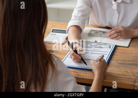 Nahaufnahme Ansicht Hände des Geschäftsmannes Unterzeichnung Leasing-Home-Dokumente und haben eine Wohnung Schlüssel auf Papierkram. Hausmiete Konzept Stockfoto