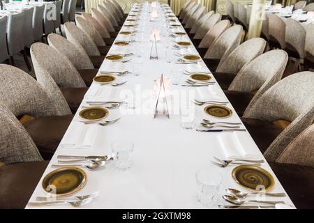 Luxuriöser Esstisch im Restaurant mit Besteck und Tellern. Stockfoto