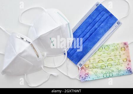 Eine Auswahl an verschiedenen Schutzmasken - ffp2 kn95 Chirurgische und bunte Kinder Gesichtsmaske auf weißer Laboroberfläche Stockfoto