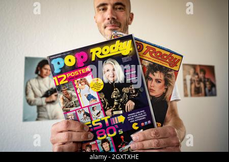 Berlin, Deutschland. Oktober 2021. Christian Kallenberg, Medienunternehmer, hält die neue Ausgabe der Zeitschrift 'Pop Rocky' (l) neben einer alten Ausgabe in seinem Büro. Das Magazin wurde 1998 eingestellt und wird mit einer Sonderausgabe auf 07.10.2021 wiederveröffentlicht. Quelle: Fabian Sommer/dpa/Alamy Live News Stockfoto