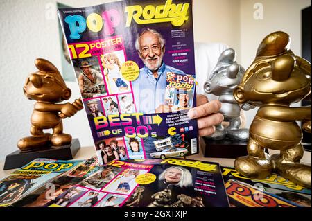 Berlin, Deutschland. Oktober 2021. Christian Kallenberg, Medienunternehmer, hält die neue Ausgabe des Magazins „Pop Rocky“ in seinem Büro. Daneben befindet sich der Hammerschlumpf in Gold und Silber, eine Auszeichnung des Magazins. Das Magazin wurde 1998 eingestellt und wird mit einer Sonderausgabe auf 07.10.2021 wiederveröffentlicht. Quelle: Fabian Sommer/dpa/Alamy Live News Stockfoto