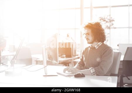 Jungunternehmer-Programmierer in großes helles Büro bei der Arbeit mit computer Stockfoto
