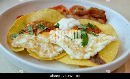 Frühstück Hard Shell Tacos und Bacon Tomaten und Eier am Morgen Mahlzeit auf einem Teller Stockfoto