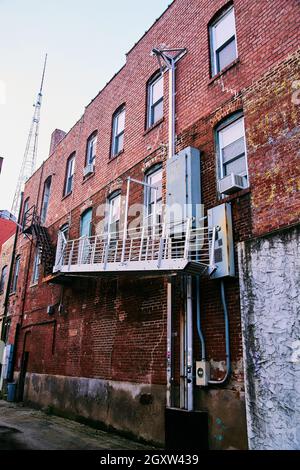 Die Rückseite des Gebäudes in der Innenstadt ist mit Ziegelsteinen und einer Metalltreppe bedeckt Stockfoto