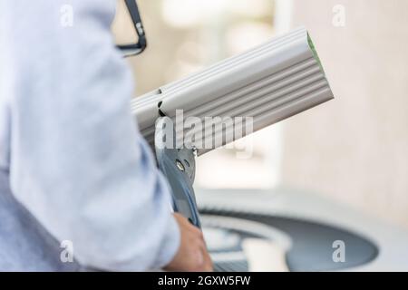 Arbeiter Schneidet Aluminium-Regenrinne Mit Schweren Scheren. Stockfoto