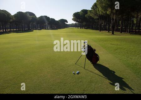 Golfbag mit Club und Ball vorne am wunderschönen Sonnenaufgang auf Kurs Stockfoto