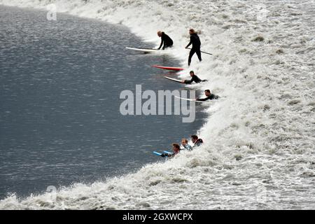 Surfer im kalten Wasser reiten auf einer gebohrten Gezeitenwelle im Turnagain Arm des Cook Inlet, Anchorage, Alaska, USA Stockfoto