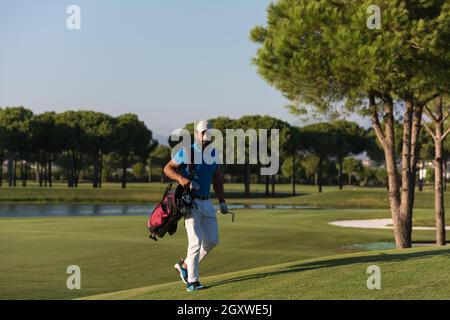 schöne orientalische Golfer Tragetasche und zu Fuß zum nächsten Loch am Golfplatz Stockfoto