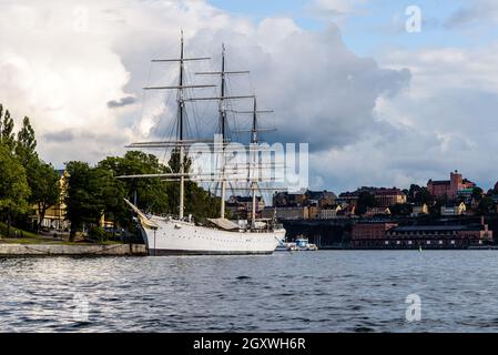 Stockholm, Schweden - 9. August 2019: Das Tall-Schiff AF Chapman vertäute im Hafen von Stockholm. Blick bei Sonnenuntergang gegen die Stadtlandschaft. Jetzt als Herberge laufen. Stockfoto