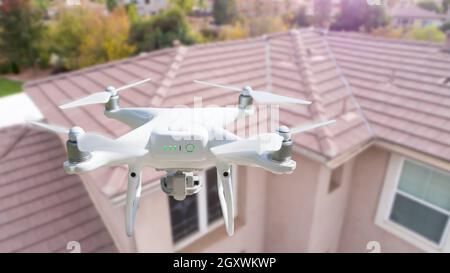 Unbemannte Luftfahrzeuge (UAV) Quadcopter Drohne in der Luft über Haus Inspektion des Daches. Stockfoto