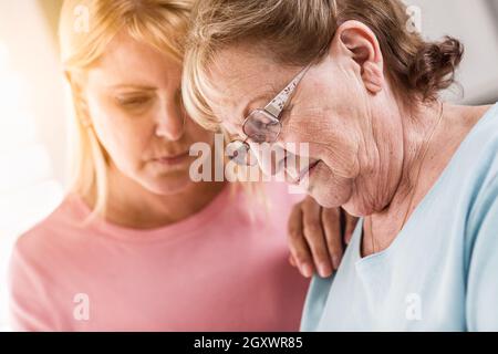 Junge Frau tröstet traurige Senior Erwachsenfrau. Stockfoto