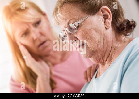 Junge Frau tröstet traurige Senior Erwachsenfrau. Stockfoto