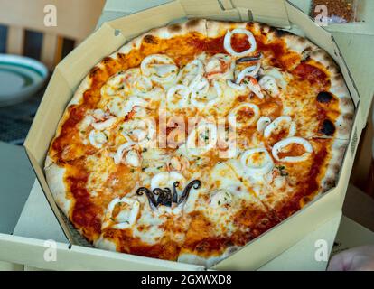 Margherita Parma Schinken / Meeresfrüchte / Rinderwurst Italienische Pizza in offener Pizzeria Brown Box. Stockfoto