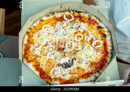 Margherita Parma Schinken / Meeresfrüchte / Rinderwurst Italienische Pizza in offener Pizzeria Brown Box. Stockfoto