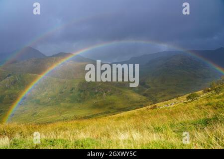Malerischer Blick mit einem doppelten Regenbogen über Täler und Berge im Snowdonia Nationalpark Wales Stockfoto