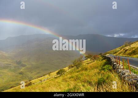 Malerischer Blick mit einem vollen Regenbogen über Täler und Berge im Snowdonia Nationalpark Wales Stockfoto