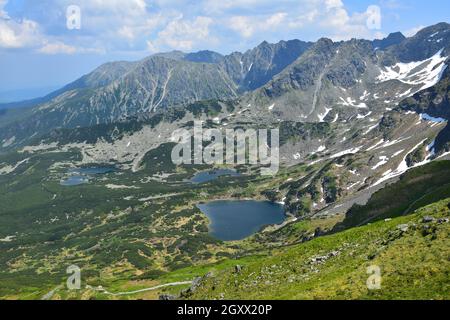 Blick vom Berg Kasprov Vrch auf die Seen Zielony staw, Kurtkowiec und Dlugi Staw, umgeben von Bergen der Hohen Tatra. Polen. Stockfoto