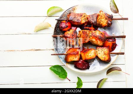 Spieße mit Schweinshauch-Kebab, Kebabs in Pflaumensoße. Grill mit Schweinefleisch Stockfoto