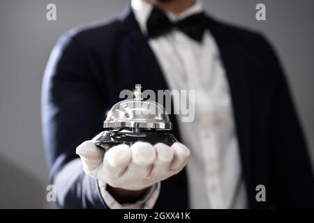 Hospitality Service Concierge In Uniformen Mit Butler Bell In Der Hand Stockfoto