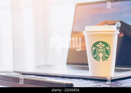 Bangkok, Thailand-September 30,2019 : Starbucks Kaffee mit heißen Getränken auf dem Arbeitstisch am Fenster. Grünes Logo Papierbecher mit heißem Kaffee Starbucks und Stockfoto