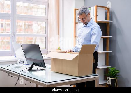 Job Beenden. Mitarbeiter Verpackt Karton Am Schreibtisch Stockfoto