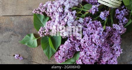 Schöne Frühlingsblumen Flieder auf alten grunge hölzernen Hintergrund, Haufen Pastellfarben Flieder, flach legen, Draufsicht Stockfoto