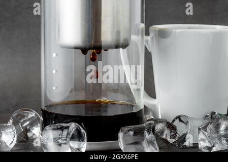 Moderne Cold Brew Drip Tower Kaffeemaschine auf dunklem Steinhintergrund Stockfoto