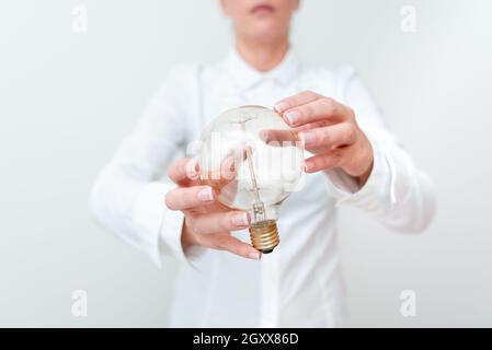 Lady Holding Lampe Mit Formellem Outfit Präsentiert Neue Ideen Für Das Projekt, Business Frau Zeigt Glühbirne Mit Zwei Händen Stellt Neue Technologien Aus, Lightbu Stockfoto