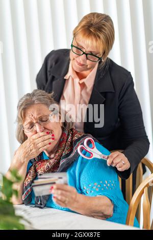 Finanzielle Berater Übergabe Schere zu den älteren Dame Holding Kreditkarten. Stockfoto