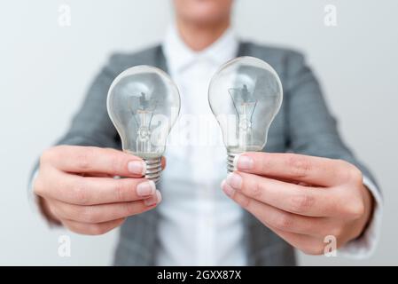 Dame Mit Zwei Glühbirnen In Den Händen Und Formellem Outfit Präsentiert Weitere Ideen Für Das Projekt, Business Woman Holding 2 Lampen Zeigt Late Technologie Stockfoto