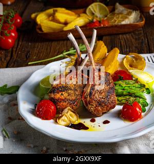 Lammkoteletts in Kräutern mit grünem Spargel und Limette mariniert Stockfoto