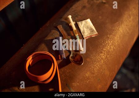 Drogenabhängige Werkzeuge, Spritze, Löffel und Tourniquet, Pulver in Zip-Paket, niemand. Suchtproblem, ewige Depression von Junky-Leuten Stockfoto