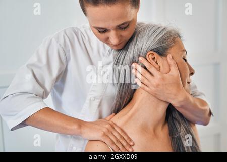 Fokussiertes Foto von Therapeuten, die Rehabilitationsmassage machen Stockfoto