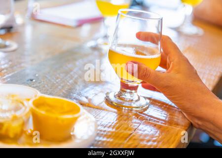 Weibliche Hand Glas Micro Brew Bier an der Bar. Stockfoto