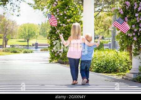 Junge Schwester und Bruder Winken amerikanische Flaggen in den Park. Stockfoto