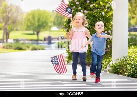 Junge Schwester und Bruder Winken amerikanische Flaggen in den Park. Stockfoto