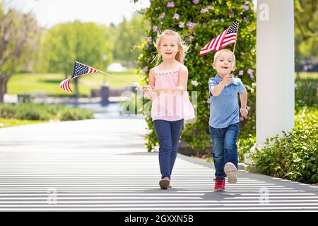 Junge Schwester und Bruder Winken amerikanische Flaggen in den Park. Stockfoto