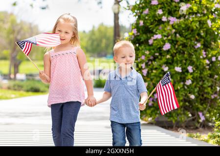 Junge Schwester und Bruder Winken amerikanische Flaggen in den Park. Stockfoto