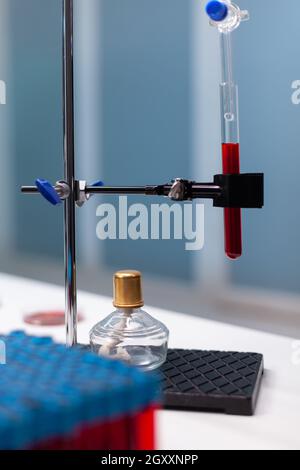 Chemisches Tropfrohr mit Reagenzglas im Wissenschaftslabor in der Klinik. Nahaufnahme des mikrobiologischen Labors mit Vakuumgeräten und chemischen Instrumenten, mit roter Substanz gefüllter Kolben zur Analyse Stockfoto