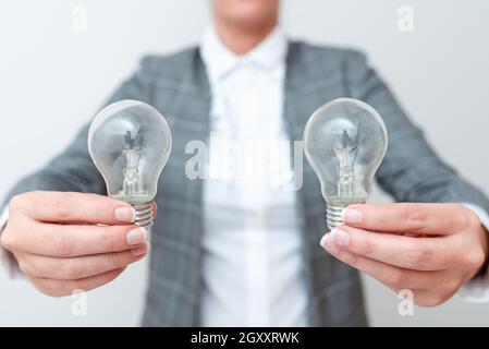 Dame Mit Zwei Glühbirnen In Den Händen Und Formellem Outfit Präsentiert Weitere Ideen Für Das Projekt, Business Woman Holding 2 Lampen Zeigt Late Technologie Stockfoto
