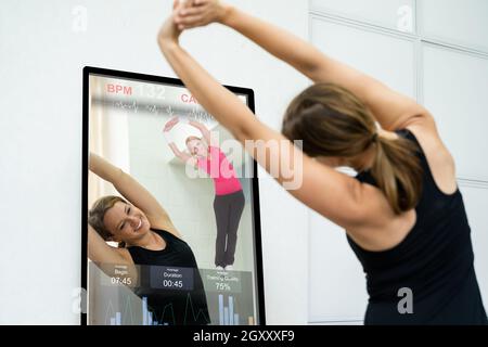 Smart Mirror Workout Und Übungsklasse. Frauen, Die Fitness Machen Stockfoto