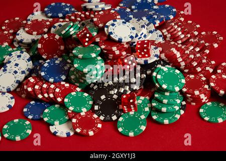 Stapel von Poker-Chips auf rotem Hintergrund im Casino Stockfoto