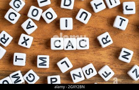 Kleine weiße und schwarze Perlenwürfel auf Holzbrett, Buchstaben in der Mitte buchstabieren CAC - Kundenakquise Kostenkonzept. Stockfoto