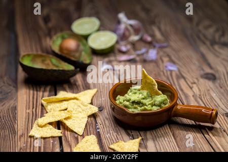 Avocado Dip mit Knoblauch, Chili, Pfeffer und Limettensaft mit Mais Nachos gewürzt Stockfoto