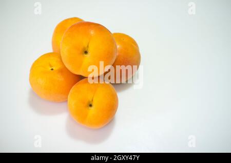 Spanische Aprikosen häufen sich. Isoliert über Weiß Stockfoto