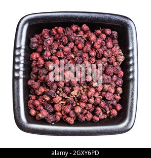 Draufsicht auf getrocknete Magnolienbeeren (Schisandra chinensis Früchte) In schwarzer Schale isoliert auf weißem Hintergrund Stockfoto