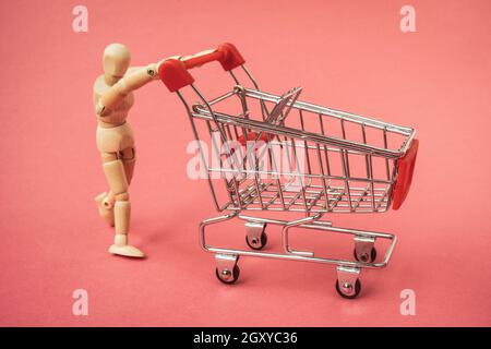 Holzmann schiebt einen leeren Warenkorb. Einkaufskonzept. Stockfoto
